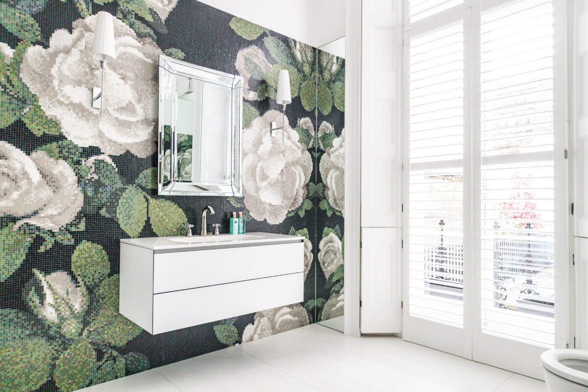 A bathroom with a black and white floral wallpaper.