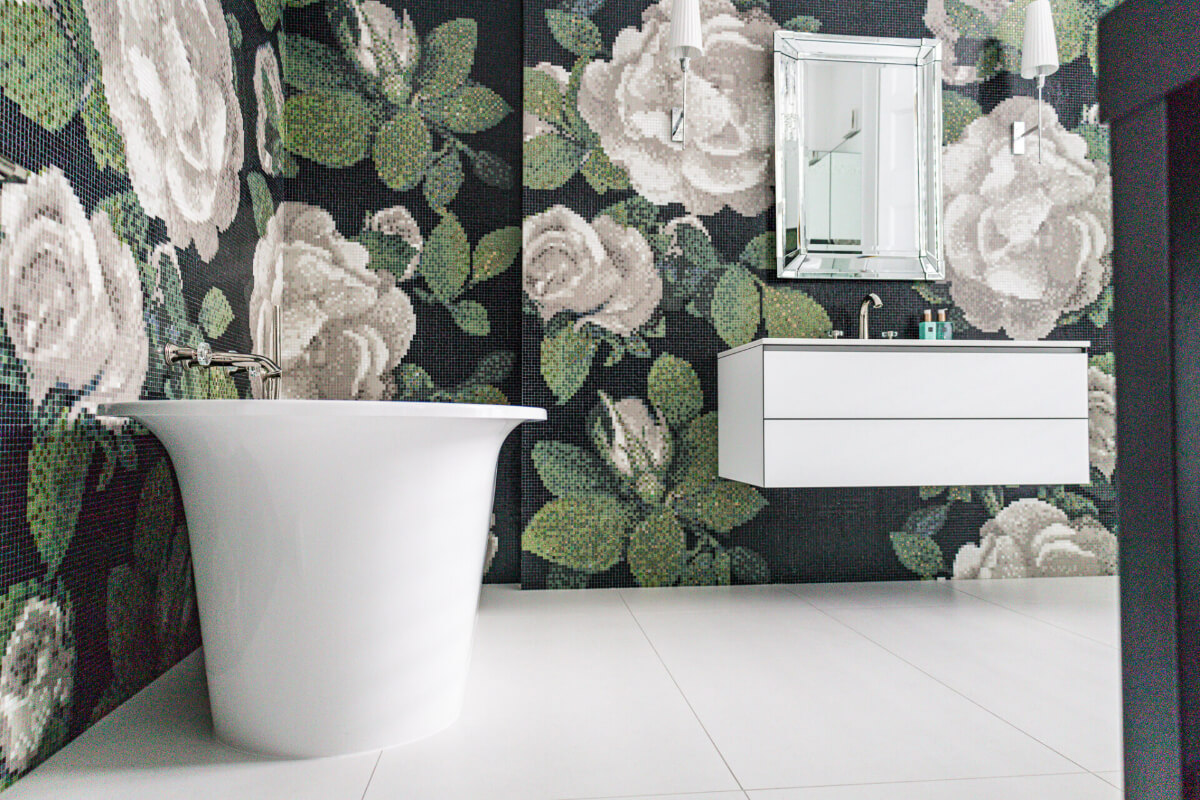 A black and white bathroom with floral wallpaper.
