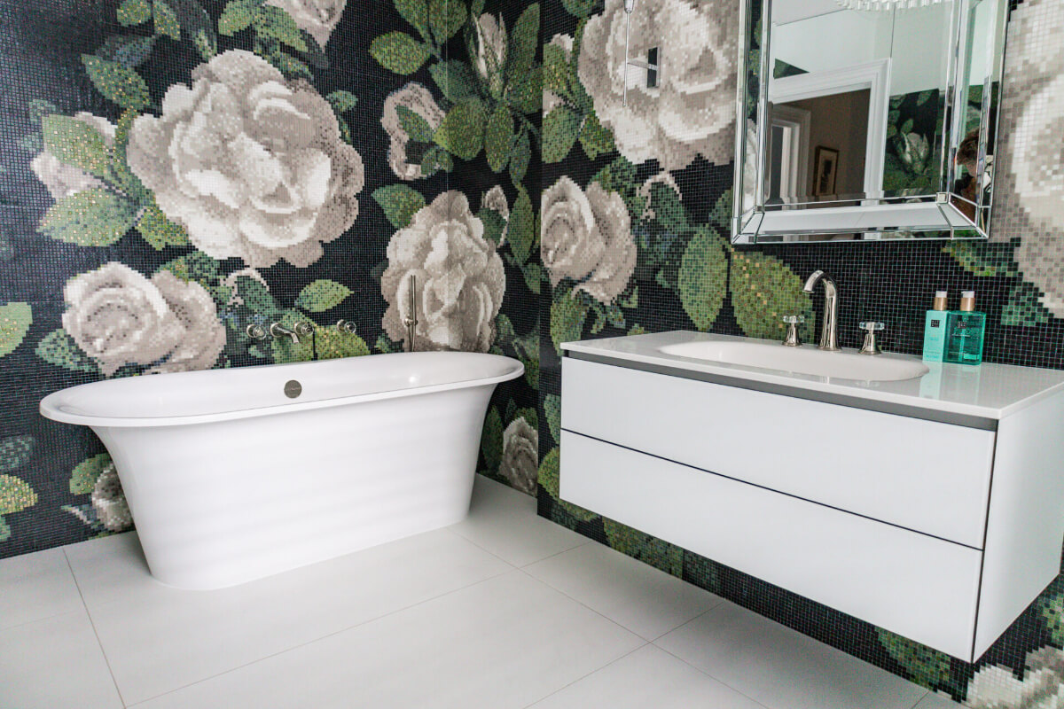 A black and white bathroom with floral wallpaper.