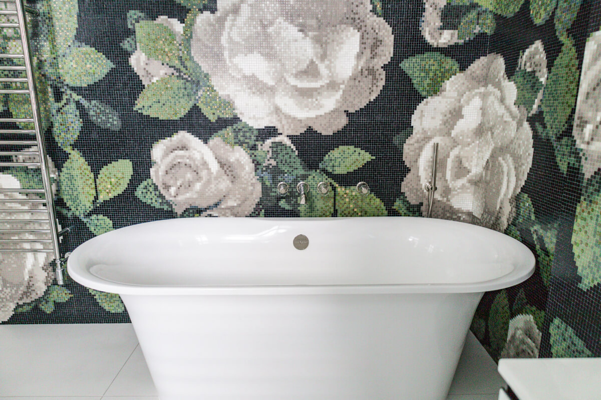 A black and white bathroom with a floral wallpaper.