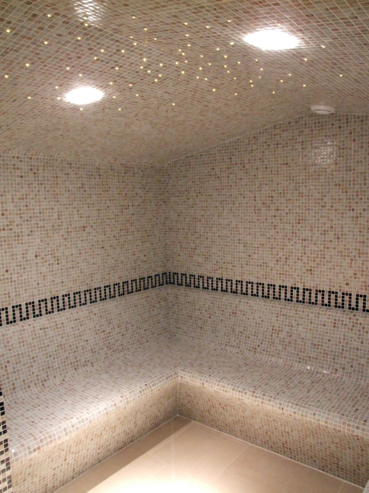 A Sauna With a Black Pattern on Mosaic Walls