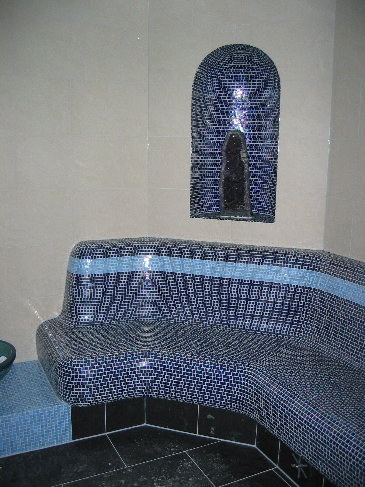 A blue tiled bench in a bathroom.