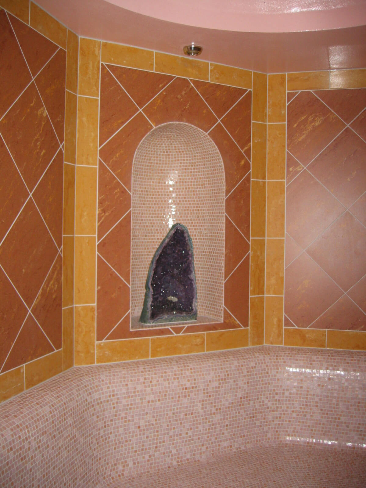 A bathroom with a tiled wall and a tiled floor.