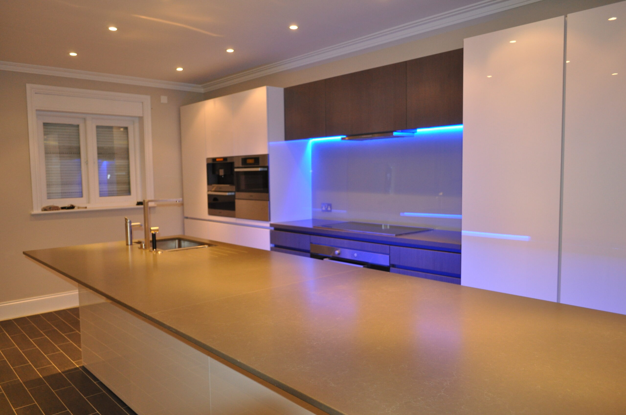 A Kitchen Space With a Large Island Counter With a Faucet