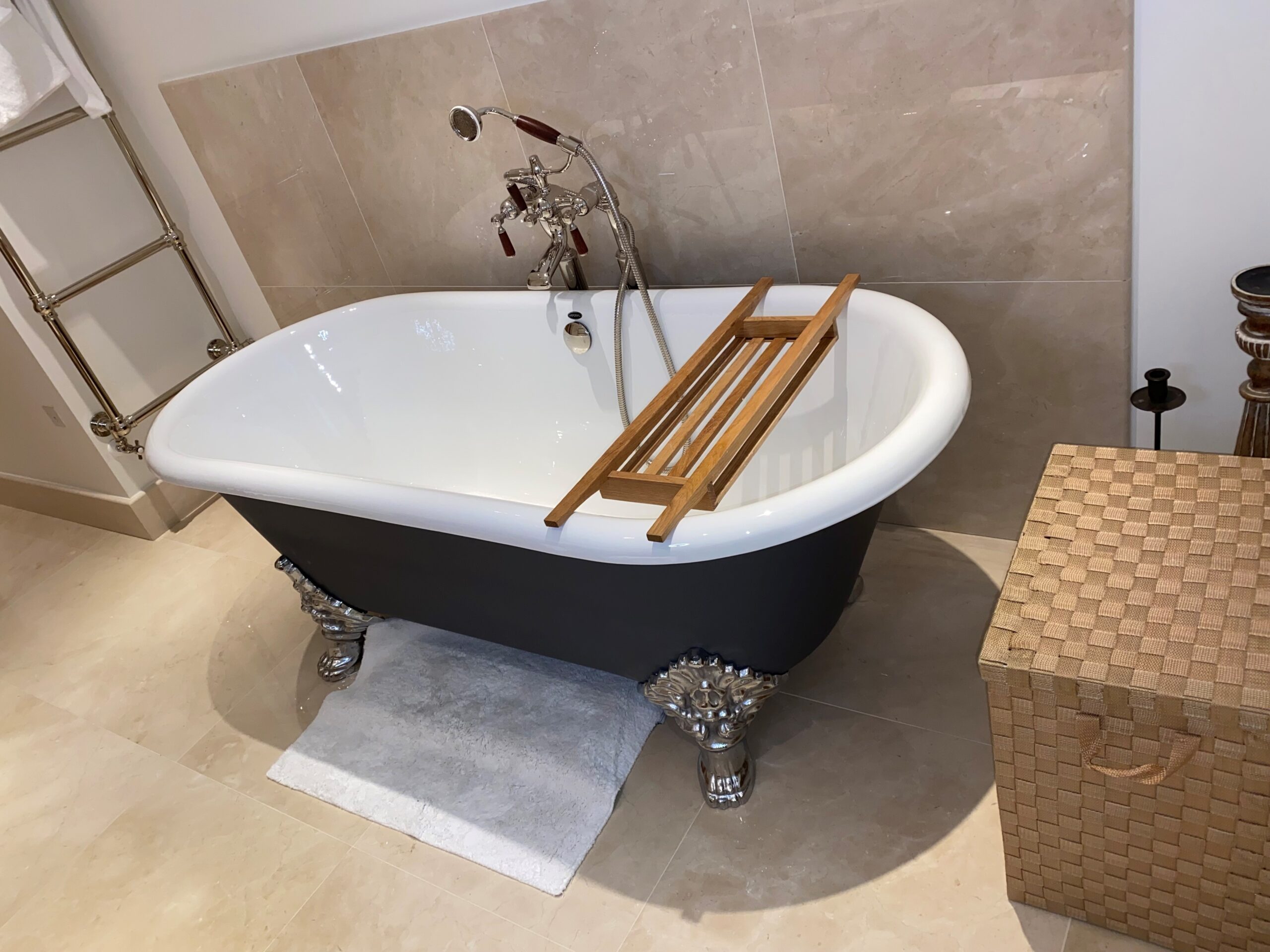 A White Tub With Black Layer and Metallic Legs